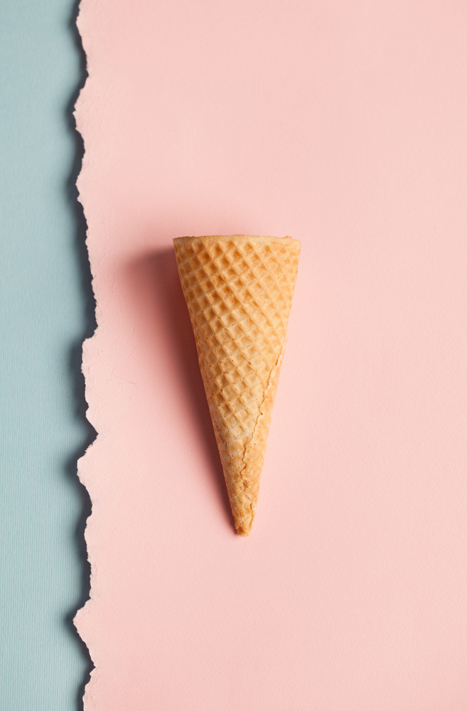 Empty ice-cream cone against a pink and blue background by luminaimages © Shutterstock Inc. All rights reserved